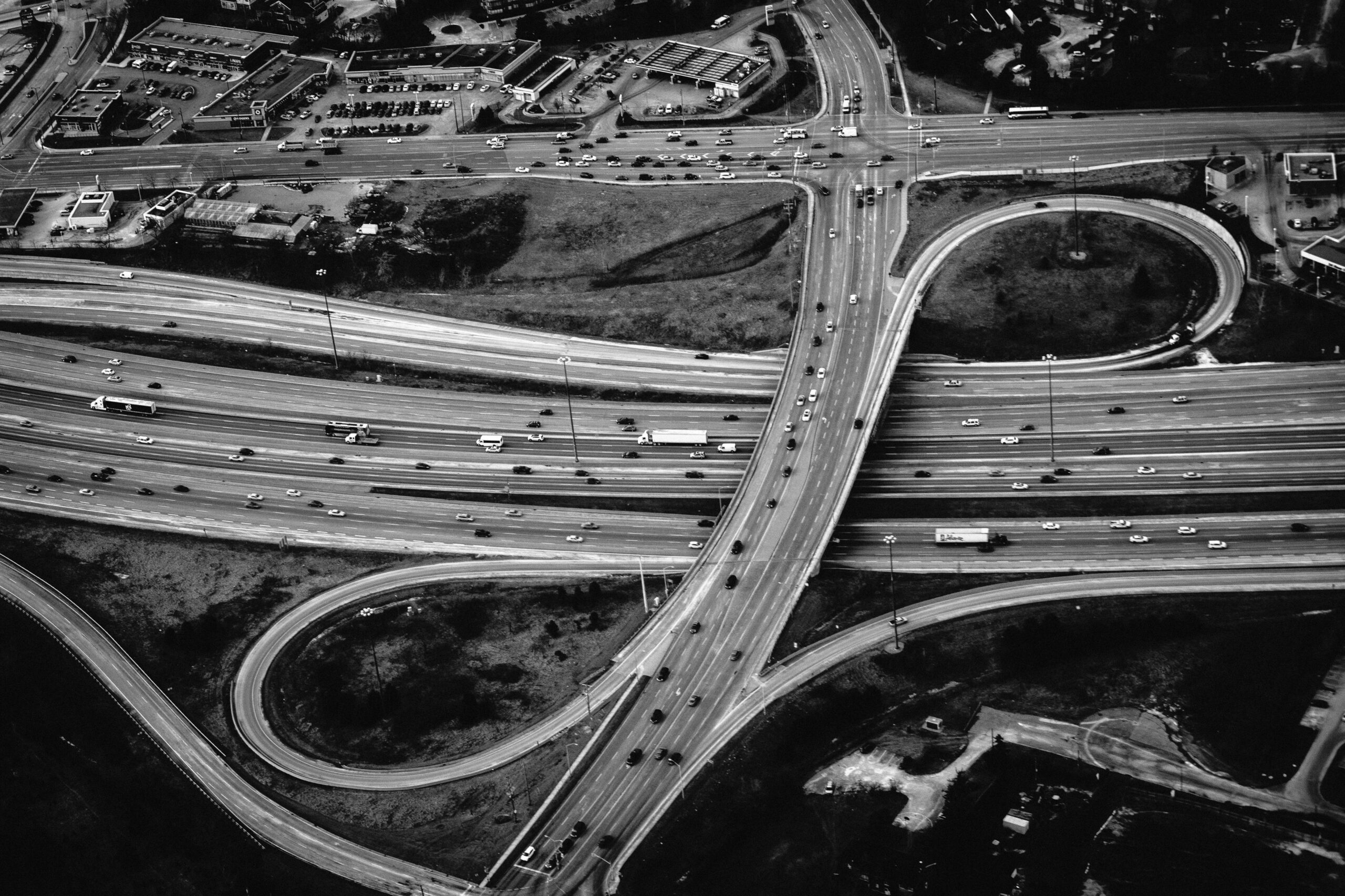 High-angle shot of a complex urban highway intersection in black and white, showcasing modern transportation.